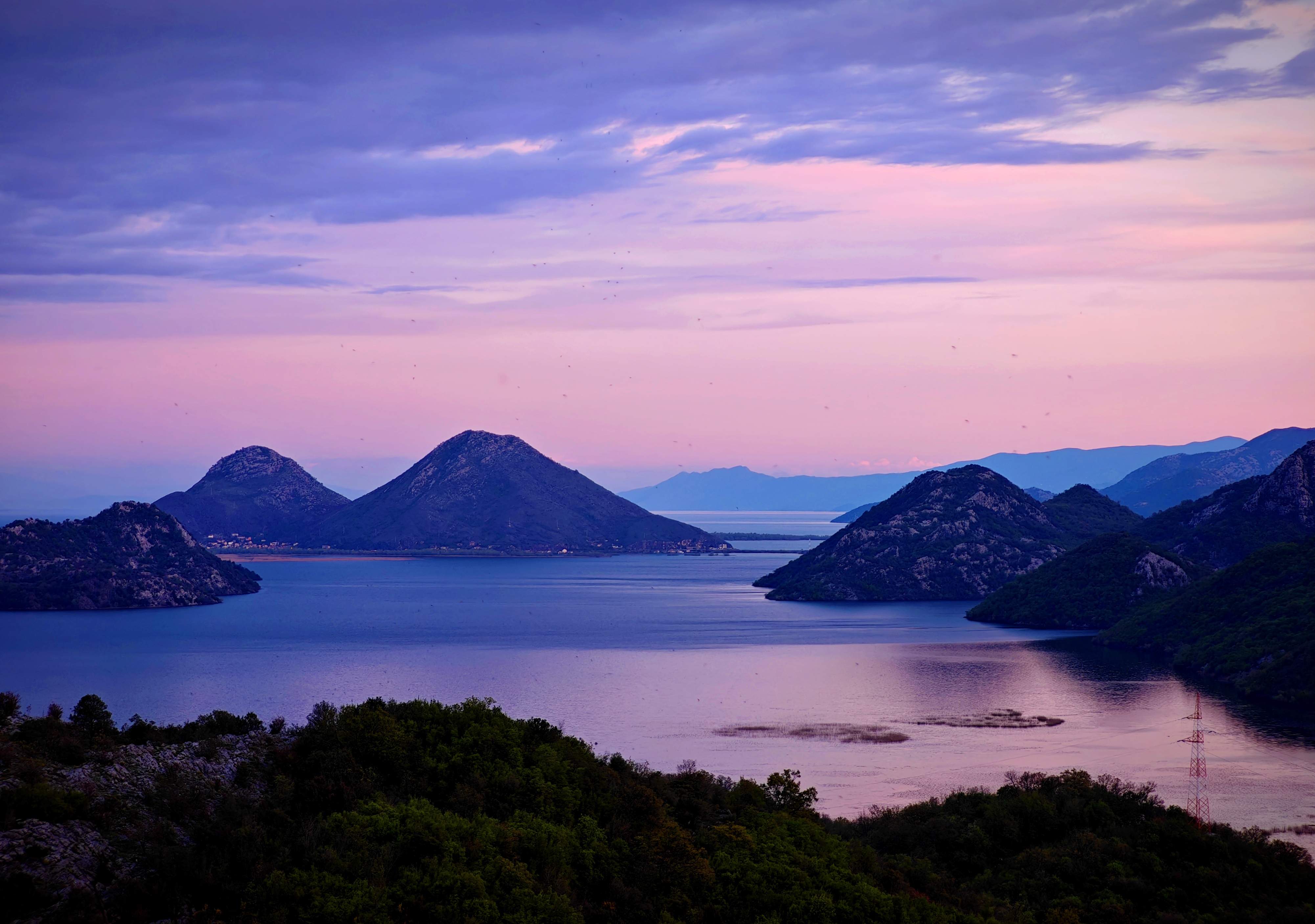 Skadar Lake at dusk with layered mountains and still water
